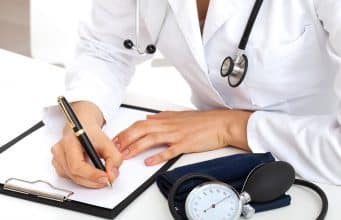 Los inmigrantes ‘sin papeles’ recuperan la asistencia sanitaria gratuita en año electoral Médico recetando a posible paciente