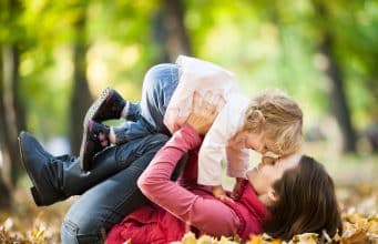 Tus hijos pueden parecerse al primer amor de tu mujer Mujer jugando en un parque con su hijo.